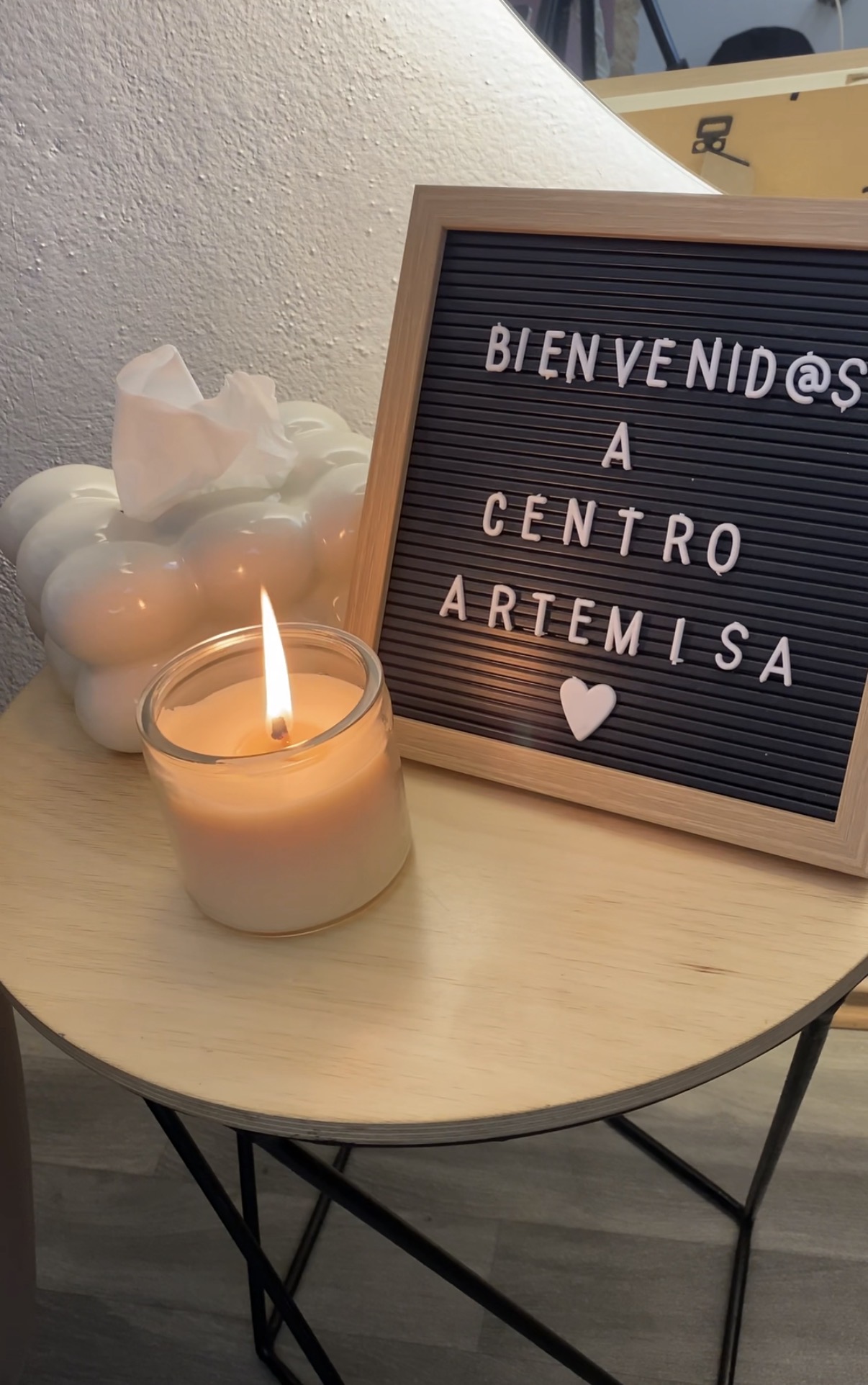 Bienvenida a Centro Artemisa — vela encendida y letrero de bienvenida en un espacio cálido